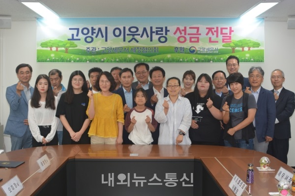 ▲ 고양세무서 세정협의회 위원들과 수혜자를 비롯한 시민들이 손하트를 보이며 활짝 웃고 있다. (사진=김경현 기자)